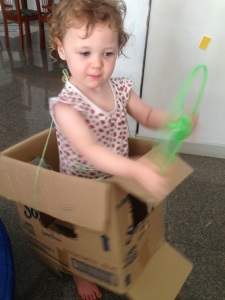 T driving her cardboard car. Not solar, but recycled.